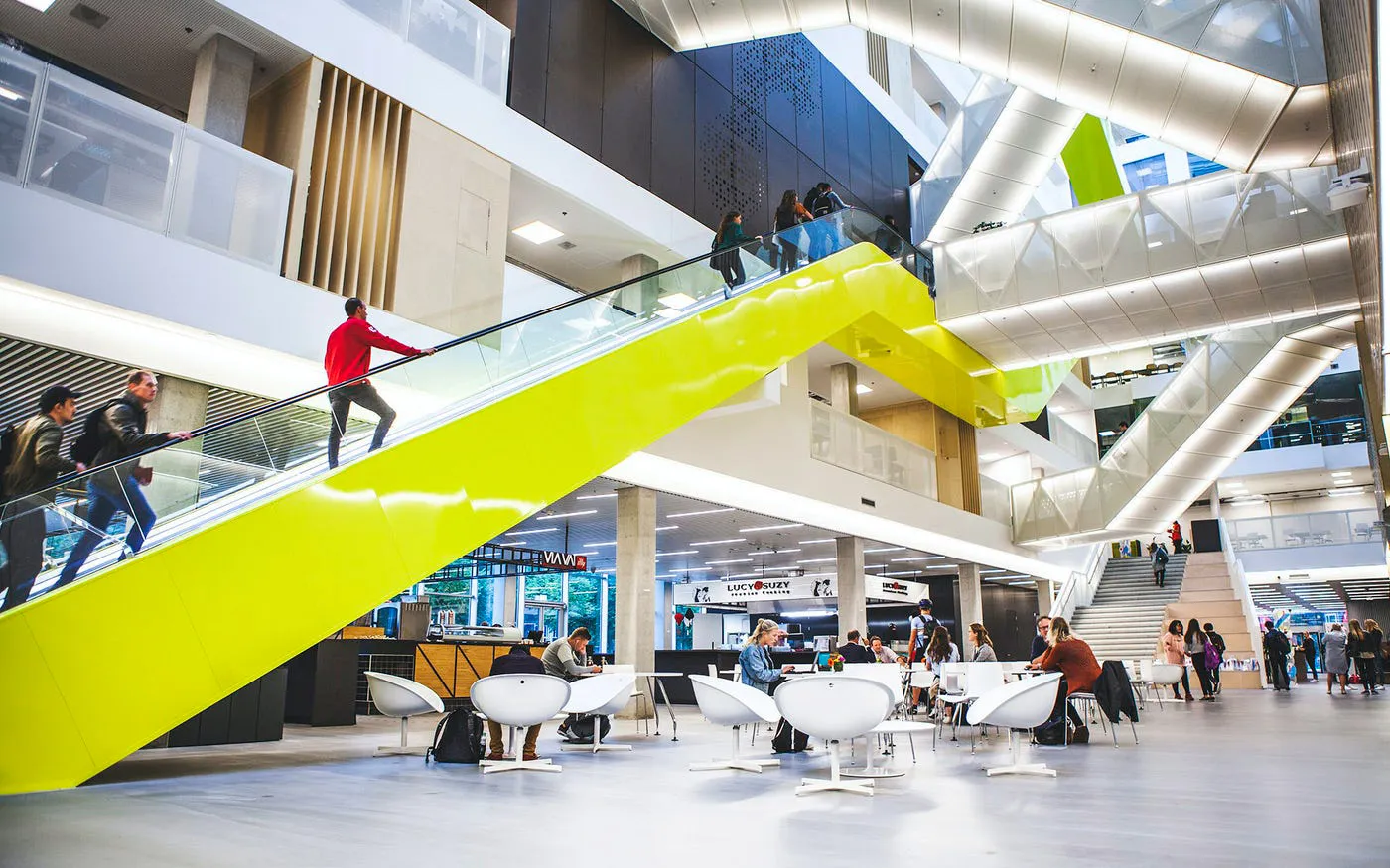 De centrale hal van Hogeschool Utrecht met een gele trap